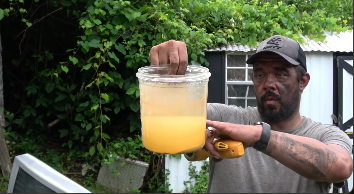 Roy New with water from his well.